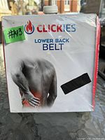 Photo of the front of the original box of the Clickies lower back belt showing brand, product name, and packaging design with a man holding his lower back.