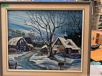 Front view of vintage oil painting on glass in wood frame showing a winter snow scene with houses and barn