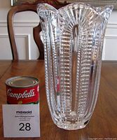 Lead crystal vase standing on a wooden table beside a Campbell's soup can and MaxSold auction card to indicate size and condition.