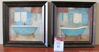 Pair of framed coordinated artworks showing clawfoot bathtubs with towels, in dark wooden frames.