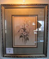 Framed floral print depicting lilies, triple matted and under glass in a decorative gold-toned frame.