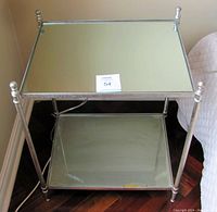Front view of the Uttermost Gannon end table showing the mirrored top and glass bottom shelf with some discoloration/residue.