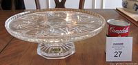 Front angle view of Violetta pinwheel lead crystal pedestal cake plate with Campbell's soup can for size comparison.