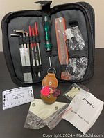 Photo showing the full Anpro guitar repair tool kit contents including tools, accessories, and instruction manual inside the carrying case and laid out in front of it.