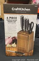 Front of the original product box displaying brand, collection name, product details and image of knife set with acacia wood block.