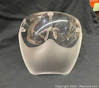 Front angled view of clear full face shield visor showing smooth surface and nose bridge support.