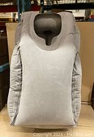 Front view of grey inflatable neck travel pillow in deflated or partially inflated state showing ergonomic headrest and side supports