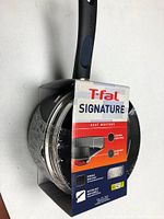 T-Fal Signature saucepan with packaging label visible, showing brand and model information.