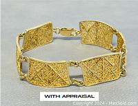 Top-down view of gold bracelet laid flat showing panel design and clasp