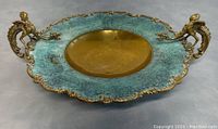 Front angled view showing the brass bowl interior, turquoise enamel rim, dragon handles, and decorative scalloped edge.