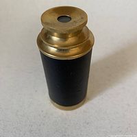 Closed spyglass showing brass and black vinyl body.