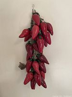 Full view of the chili pepper cluster hanging on wall, showing size and arrangement