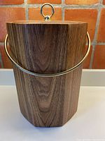 Front view of the large vintage style wine cooler/ice bucket featuring a wood-look vinyl finish with brass-tone carry handle.