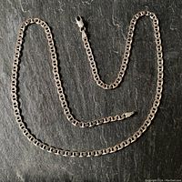 Full view of 20 inch sterling silver "Marina" chain necklace with clasp on dark textured background.