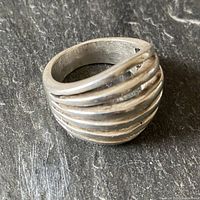 Side angled view of chunky multi-layered sterling silver men's ring showing six sliced layers and gaps