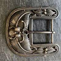 Full view of the vintage sterling silver belt buckle showing the textured foliage and beetle design, with patina.