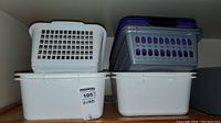 Photo showing stacked white and purple plastic baskets in various sizes.
