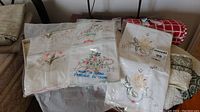 Vintage pillowcases in original plastic packaging with floral embroidery and 'Made in India' labels, stacked with assorted towels