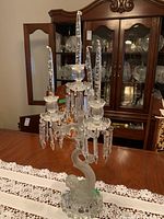 Full view of candelabra on dining table with china cabinet in background