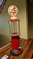 Full view of red and white reproduction gas pump with 'Roar with Gilmore' logo and measurement gauge.