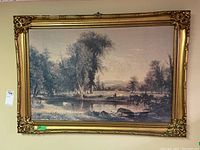 Full view of the framed pastoral scene print showing the ornately detailed frame and the entire image including trees, cows, pond, and distant hills.