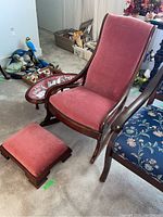 Full view of pink velvet upholstered antique rocking chair with matching footstool and kidney-shaped side table with glass top