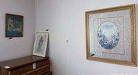 Wide shot showing three framed prints on walls near dresser