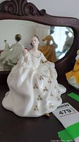 Front side of Royal Doulton My Love HN2339 porcelain figurine showing detailed white dress with gold floral designs and pink rose.