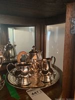 Silverplate tea set displayed together including creamer, sugar bowl, teapot, and serving tray.