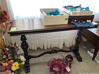 Full view of the vintage wooden trestle table showing top surface and legs with decorative carvings