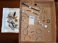 Photo of all watches, cufflinks, tie clips, pocket tools laid flat in box showing full contents