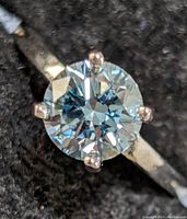 Close-up of round brilliant-cut stone showing facets and four-prong setting