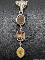 Front close-up view of the 14K white gold pendant showing the three natural diamonds in brown and yellow hues.