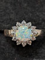 Top-down view showing round opal center and surrounding halo stones.