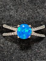 Front view of sterling silver ring with round blue opalite stone on textured silver double band.