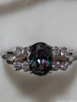 Front view of marquis-designed sterling silver ring with central oval mystic CZ and surrounding clear marcasite stones.