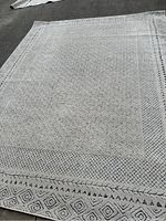 Photo showing full view of the 8x10 cream and grey area rug with detailed geometric pattern.