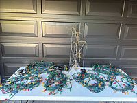 Wide shot showing 6 sets of multicoloured Christmas string lights spread on table