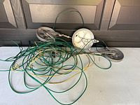 Outdoor clothesline showing paddle wheels, pulleys, and green/yellow coated hanging lines.