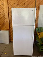 Front view of the white Roper refrigerator showing top freezer and handles.