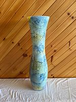Front view of a tall aqua/green/blue glaze ceramic vase showing its pattern and shape.