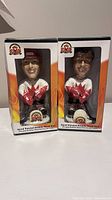 Front view of two bobble heads in original packaging displaying Paul Henderson and Frank Mahovlich in Team Canada 1972 hockey uniforms.