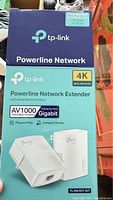 Box of TP-Link Powerline Network Extender showing model TL-PA7017 Kit and features such as AV1000, 4K UHD support, Gigabit Ethernet port