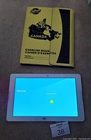 Acer Iconia One tablet powered on showing welcome screen, with yellow Hilroy magnetic cover beside it