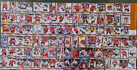 Photo showing all 100 Team Canada hockey cards laid out flat in rows, featuring players in red, white, and black Canadian team uniforms.