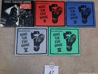 Five 'Give 'Em The Boot' CD album covers for volumes I through V laid out on the floor, showing the distinct colors and boot print artwork.