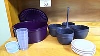 Purple round container with lid, gray condiment holder with stirring spoon, 4 condiment cups, 4 plates and 4 translucent cups