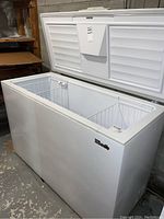 Front and open top view of white Woods chest freezer with two wire baskets inside