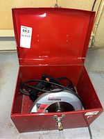 Open red metal case showing Craftsman 900 circular saw inside, cord wrapped around handle