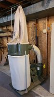 Overall side view of the assembled dust collector showing lower and upper fabric bags on casters
